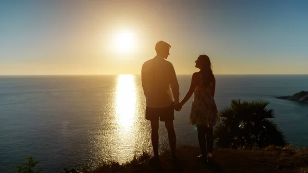 Couple tenant la main va au bord du point de vue au coucher du soleil merveilleux — Photo