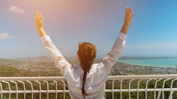 Jeune femme en chemisier blanc lève les mains admirant le paysage — Photo