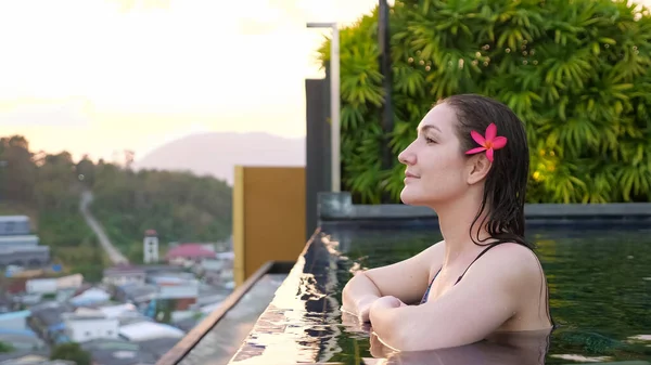 Junge Frau mit Blume im nassen Haar bewundert Landschaft — Stockfoto