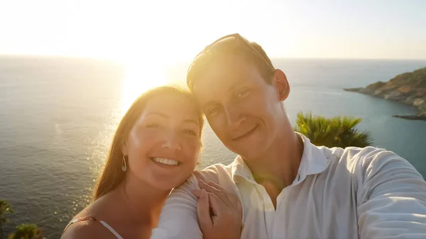 Pár dělá selfie a dáma v letních šatech objetí muž — Stock fotografie