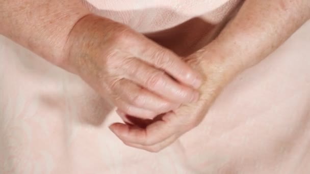 Starsza kobieta bada swoje palce. Ręce do góry — Wideo stockowe
