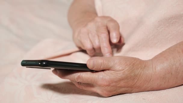 Fechar as mãos de uma mulher idosa com um telefone — Vídeo de Stock