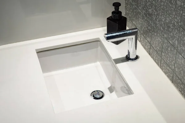 Automatyczny mieszalnik wody nad umywalką białą — Zdjęcie stockowe