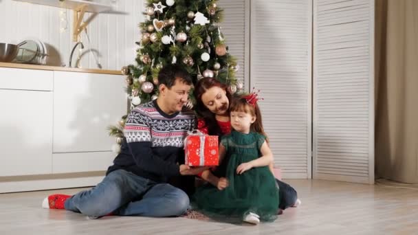 Niña niño desempaca caja de regalo con los padres por árbol de Navidad — Vídeos de Stock