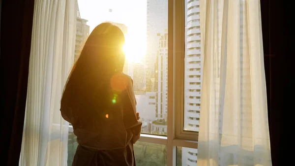 Silhouette de femme regardant les gratte-ciel à l'extérieur fenêtre — Photo