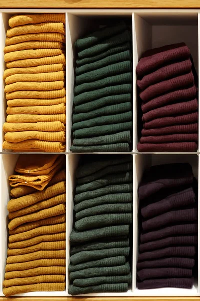 Shelves with evenly folded pullovers in different colors — Stock Photo, Image