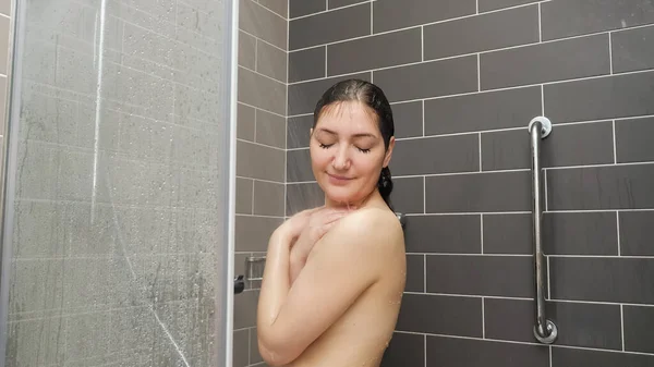 Mujer joven pelo se levanta bajo la ducha — Foto de Stock