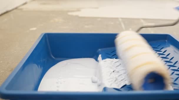 Het nemen van witte acrylverf met roller in blauwe plastic lade — Stockvideo