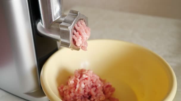Memasak daging cincang di rumah menggunakan penggiling listrik. Mangkuk plastik dengan daging cincang di atas meja. — Stok Video