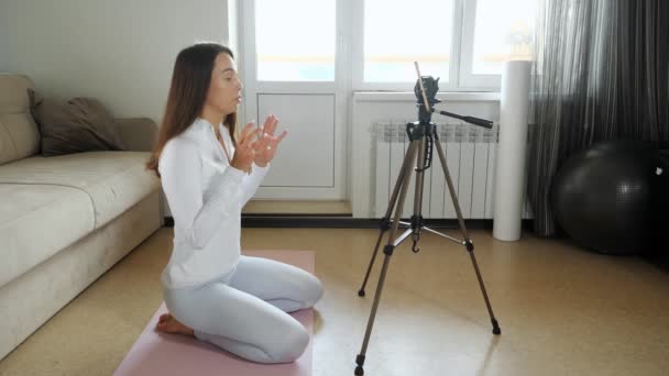 Mujer entrenador dispara video tutorial con teléfono en casa — Vídeo de stock