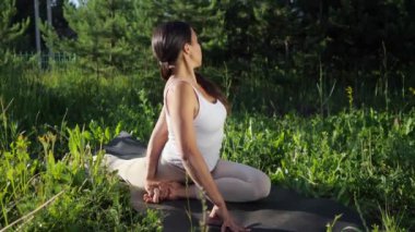 Genç kadın doğada yoga yapıyor.