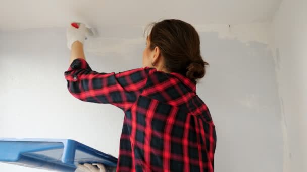 Señora con pinturas contenedor de pared en gris claro en la terraza — Vídeos de Stock