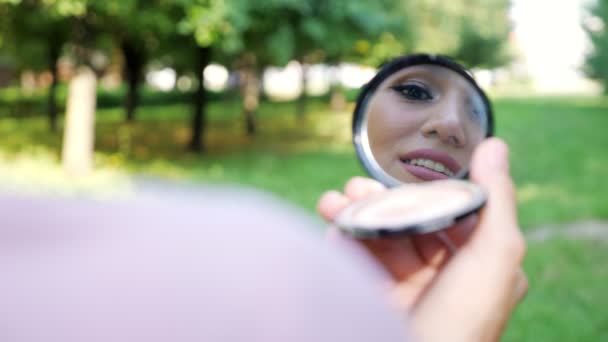 ピンクのヒジャーブのエレガントな若い女性は小さな鏡に映る — ストック動画