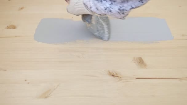 Žena maluje dřevěný povrch se světle šedou barvou v pokoji — Stock video