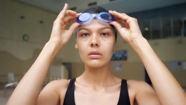Dame setzt Schutzbrille auf, um in moderner Pool-Nahaufnahme zu trainieren — Stockvideo