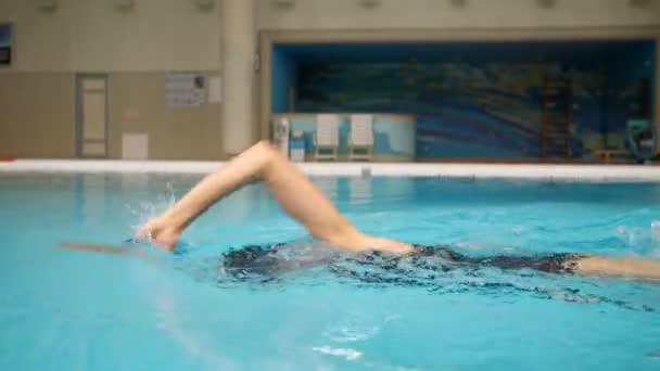 Kobieta w czarnym stroju kąpielowym czołga się do basenu w zwolnionym tempie — Wideo stockowe