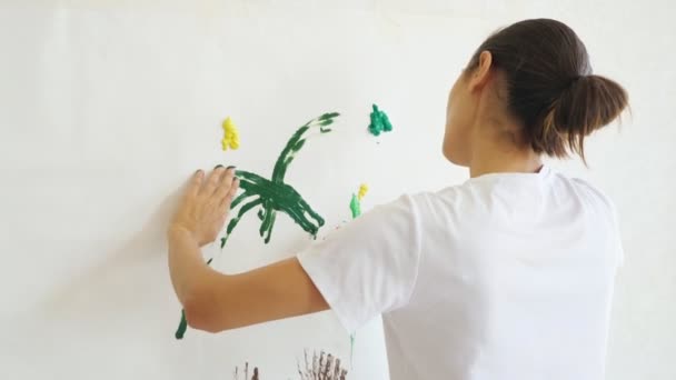 Artiste inspiré en t-shirt dessine avec des peintures jaunes vertes — Video