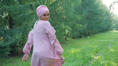 Mor elbiseli ve tesettürlü profesyonel model çimenlerde poz veriyor