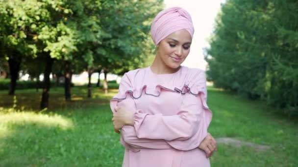 Vrouw draagt een effen tulband hoofddoek glimlachend — Stockvideo