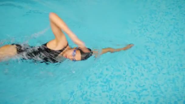 Kvinna idrottsman i svart kostym simmar främre krypa stil i poolen — Stockvideo