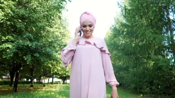 Jeune femme en robe avec hijab parle sur smartphone noir — Video