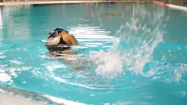Sporcu kadın temiz havuz suyunda ön emekleme stili yüzüyor. — Stok video
