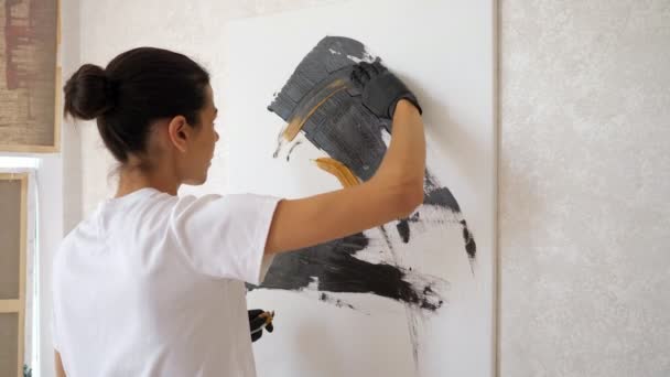 Artista en camiseta dibuja pintura de colores negro y amarillo — Vídeo de stock