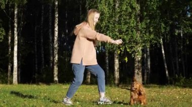 Uzun sarı saçlı liseli kız Rus spanyeliyle oynuyor.