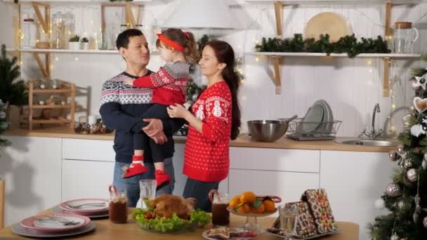 Dziewczyna całuje ojciec co rodzice śmieją się w pobliżu świątecznego stołu — Wideo stockowe