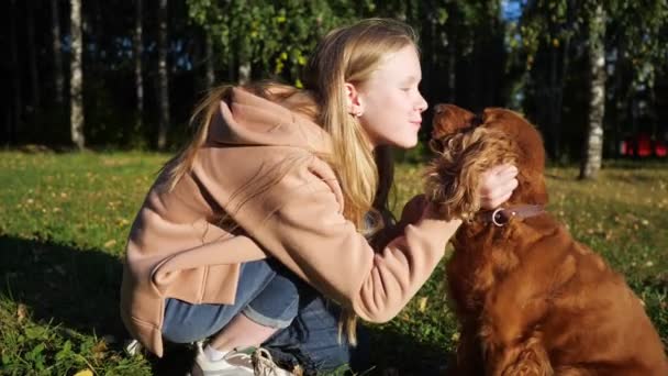 Tonårstjej med långt löst vackert hår husdjur och kysser hund — Stockvideo