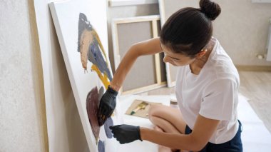 Beyaz tişörtlü esmer ve siyah şortlu resim çiziyor