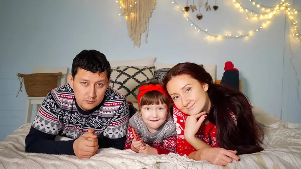 Famiglia si trovano sul letto accogliente e guarda la fotocamera — Foto Stock