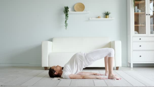 Gravid dame øver på yoga hjemme. – stockvideo