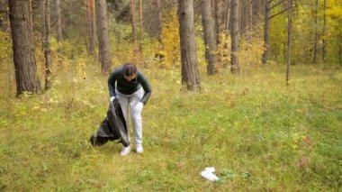 Ormanda çöp toplayan genç bir kadın.