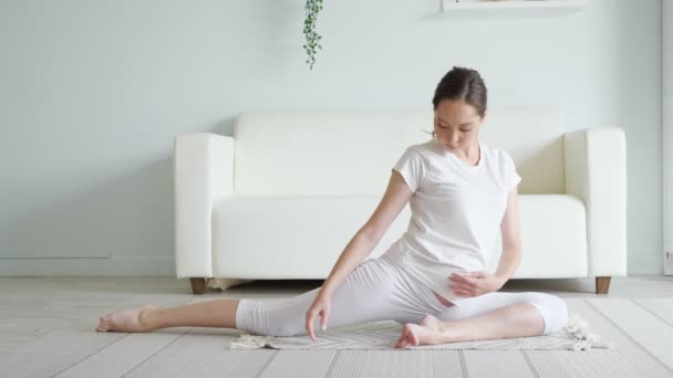 Mulher grávida calma faz ardha matsyendrasana posar em casa — Vídeo de Stock