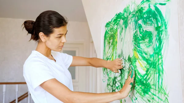 Profesional chica artista dibuja verde amarillo blanco pinturas — Foto de Stock