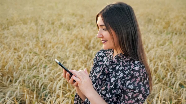 Fiatal nő telefon érett búza mező — Stock Fotó