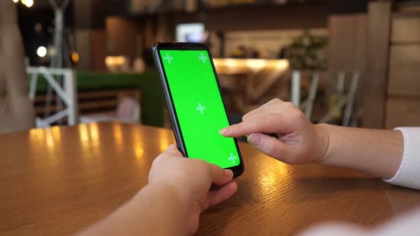 Жінки руки тримають телефон з зеленим екраном і торкаються його — стокове відео