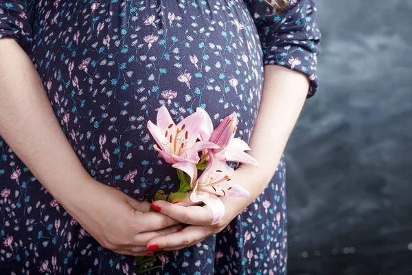 Крупный План Беременной Женщины Держащей Цветок Трогающей Живот — стоковое фото