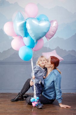 Anne ve oğlu balonlarla oynamayı. Mutlu aile kavramı. Çocuk Doğum günü