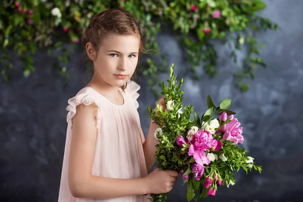 Bir buket çiçek ile portre sevimli küçük kız. Kameraya bakarak