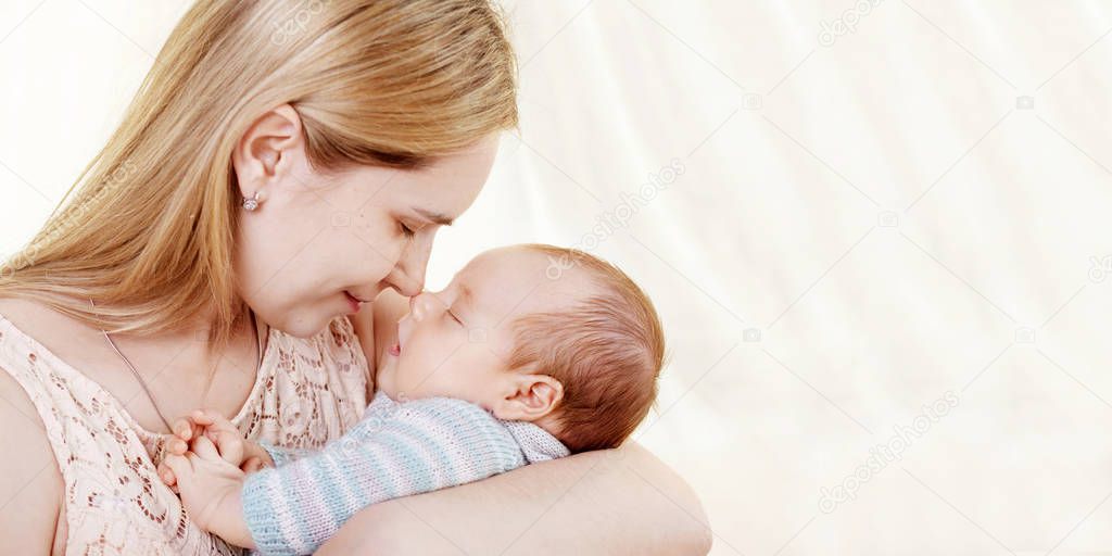 Pretty woman holding  newborn baby in her arms. Close up image with  copy space. Motherhood concept. Happy family concept