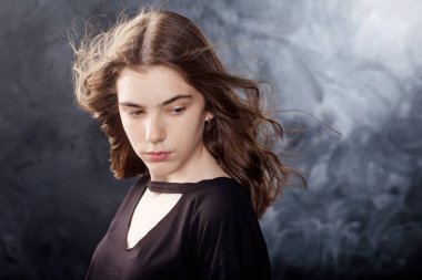 Saç çırpınan ile güzel genç kız portresi. Kızın yüzü siyah arka plan üzerine saçlarında rüzgar ile