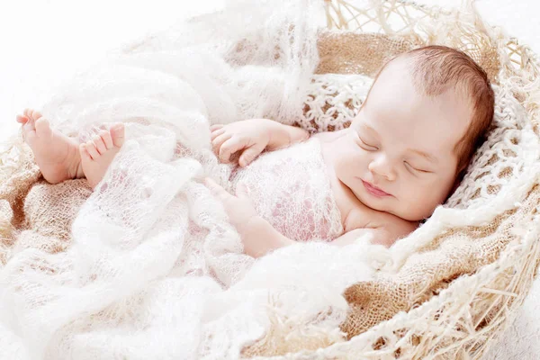 Beautiful little newborn boy 3 weeks sleeps in a basket with knitted plaid. Portrait of pretty smiling newborn boy — Stock Image Beautiful Little Newborn Boy Weeks Sleeps Basket Knitted Plaid Portrait Stock Photo