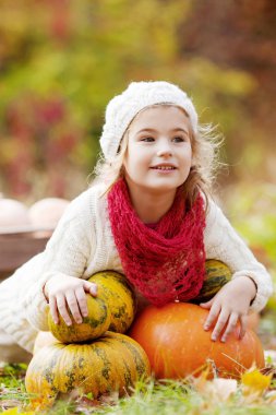 Kabaklar Sonbahar Park ile oynayan sevimli küçük kız. Çocuklar için sonbahar aktivitelere. Aile için Cadılar Bayramı ve Şükran zaman eğlenceli.