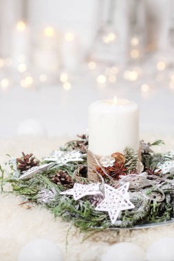 Noel mumlar ve karlı köknar dalları ışıkları ile beyaz ahşap zemin üzerinde. Beyaz tonlarda bir köknar ağacı Yılbaşı dekorasyonu.