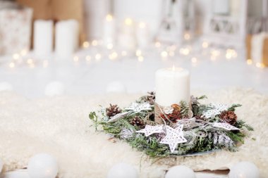 Noel mumlar ve karlı köknar dalları ışıkları ile beyaz ahşap zemin üzerinde. Beyaz tonlarda bir köknar ağacı Yılbaşı dekorasyonu.