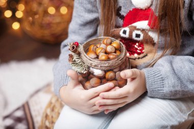 Banka fındık holding kızın eller. Noel ve yeni yıl kavramı. Bokeh ve güneş ışığı ile şenlikli arka plan. Sihirli peri masalı