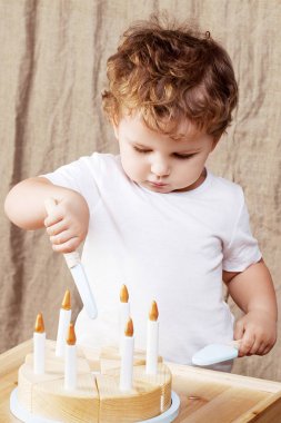 Ahşap oyuncak pasta ile odasında oynayan çocuk çocuk