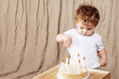 Çocuk çocuk odasında bir ahşap oyuncak pasta ile oynarken. Kopya alanı